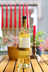 Bottle of white wine with a blank label for package design. Kosher white wine on a wooden table.