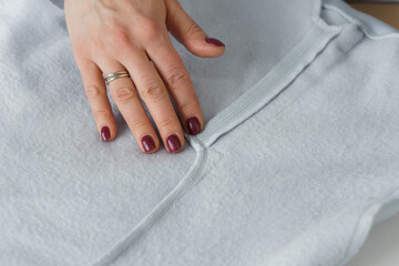 Seamstress look at ready clothes. Garment factory quality control check for defects. Tailors work