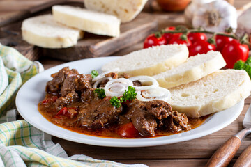 Homemade hot Czech goulash with knodel in a plate close-up. horizontal