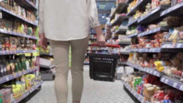 Woman holding empty shopping basket. Women carrying full shopping basket in grocery store. A woman is holding the empty basket in super market