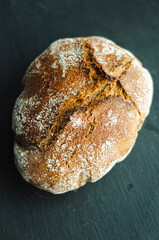 homemade round yeast bread delicious baking on a black background, space for text
