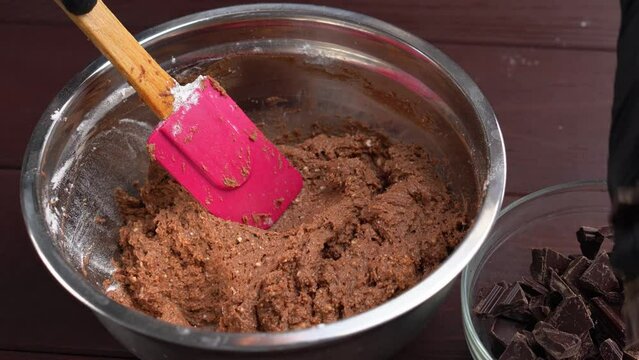 Closeup view of male hands preparing dough mixing flour with chocolate using whisk in kitchen