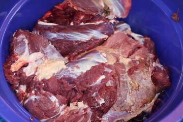 Making the process of tasty fresh beef meat. close up and texture of Traditional Red beef meat. Meat food background. White, blue, red, and black bucket