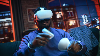 Cinematic Portrait of a Young Stylish Black Man Using Virtual Reality Headset with Joysticks....