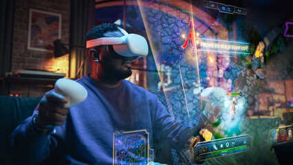 Cinematic Portrait of a Young Stylish Black Man Wearing Virtual Reality Headset. African American Man Sitting on a Sofa at Home And Playing VR Game. Visualization of Gameplay Concept. © Gorodenkoff
