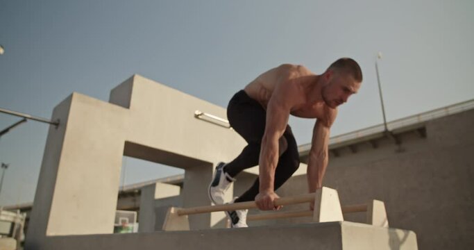 Sportsman doing handstand on bars