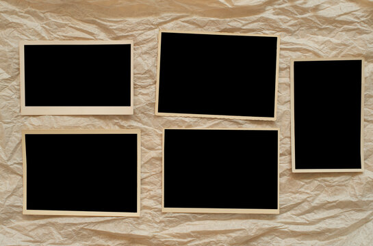 vintage empty photo frames, grungy blank postcards on crumpled paper background, free space for pictures