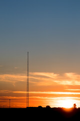 Fototapeta na wymiar Telecommunications mast with telephone antenna against the rising sun, telephone coverage, telecommunications, telecommunications infrastructure