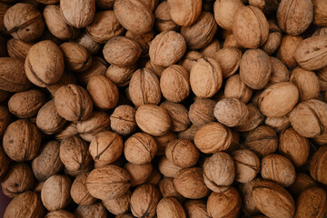 Walnuts with shells. Filled background. Walnuts texture. Abstract nuts heap pattern background
