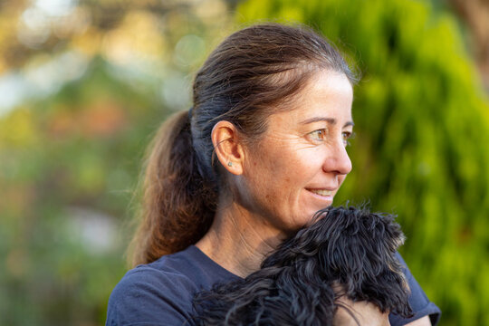 head and shoulders of woman holding small dog