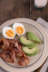 Breakfast with bacon, eggs and coffee on a wooden table