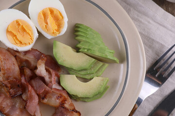 Breakfast with bacon, eggs and coffee on a wooden table
