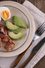 Breakfast with bacon, eggs and coffee on a wooden table