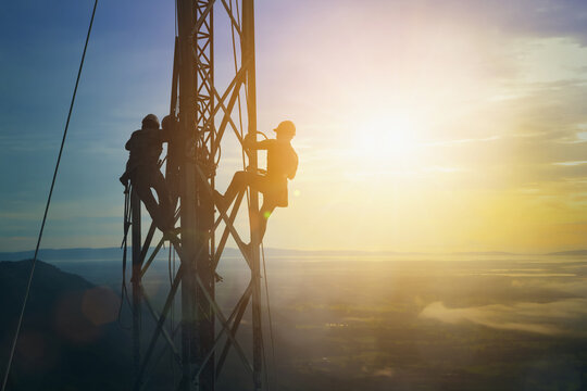 Silhouette electrician work on high ground heavy industry concept. Construction of the extension of high voltage in high voltage stations safely.