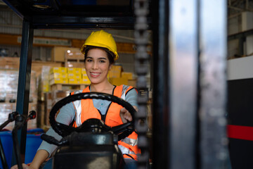 Portrait of woman forklift driver in factory, Woman cargo worker work in warehouse.