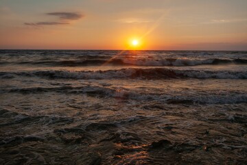 Evening orange sky with dramatic clouds and sea