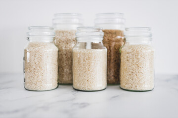 glass jar with rice of different varieties including jasmine basmati arborio sushi and brown rice,...