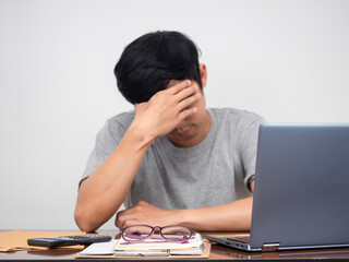 Sad man sit holding head at working table