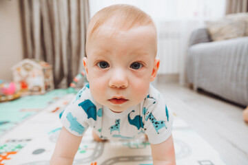 Above angle shot of adorable Baby boy lying on child friendly floor puzzle mats looking up