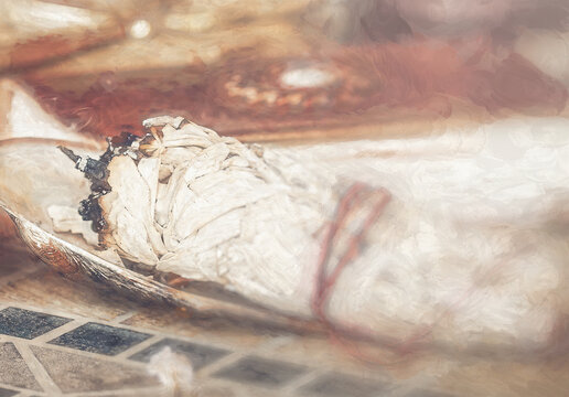 A close up image of a burning white sage smudge stick used for energy clearing and healing.