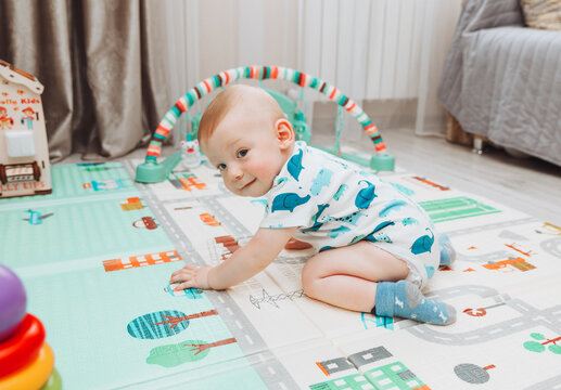 Above angle shot of adorable Baby boy lying on child friendly floor puzzle mats looking up