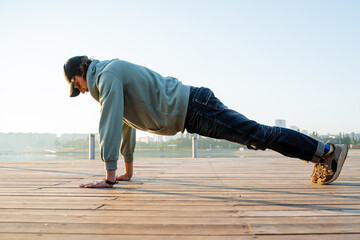 The guy performs the plank exercise, the handstand rest lying down, push-ups from the floor,...