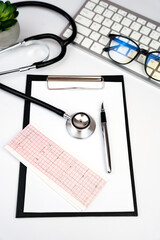 Doctor's workplace with stethoscope, clipboard and glasses. Close-up. Top view. Selective focus.