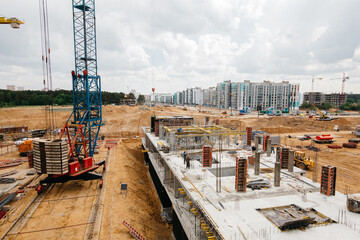Construction site background. Hoisting cranes and new multi-storey buildings
