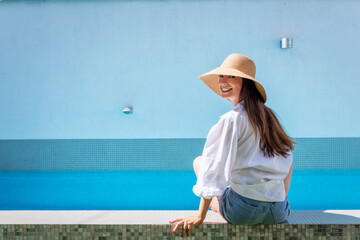 Woman relaxing by the pool at summer time