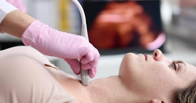 The doctor makes an ultrasound of the thyroid gland