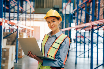 Portrait of female worker using laptop working in warehouse, Industrial and industrial workers...