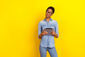 Portrait of minded doubtful person look interested empty space pouted lips isolated on yellow color...