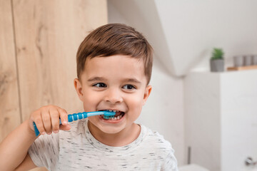 Child brushing teeth. Kids tooth brush and paste. Little funny baby boy brushing his teeth in modern bathroom on sunny morning. Dental hygiene and health for children