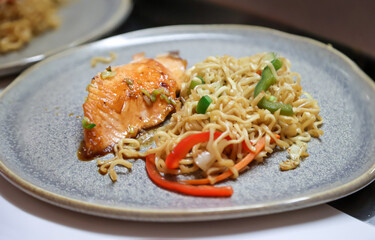 Lachs und Nudeln auf einem Teller. Essen wir bei einem japanischen Restaurant zubereitet.
