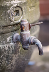 An einem alten Bierfass ist ein Ablasshan angebracht.
