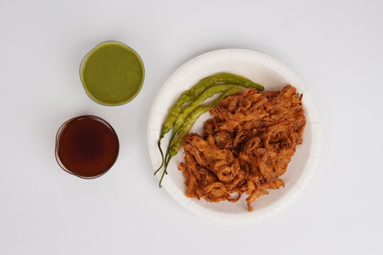 Kanda Bhajia In Plate With Green Chutney And Imli [tamarind] Chutney