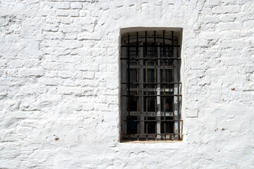 Prison cell window with bars, old stone citadel architecture detail. Window of an old prison on a...