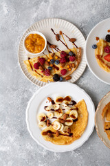 Overhead view of plate with breakfast crepes with berries and bananas