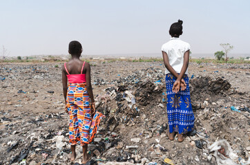 Two teenage girls standing in a landfill, symbolizing the lack of future prospects for young...