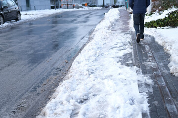 part of street in city, pavement after heavy snowfall, wet snow melts, puddles, slush and mud...