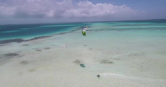 KITESURF near  reef barrier,  man sail on turqoise sea, AERIAL TRAKING SHOT, LOS ROQUES
