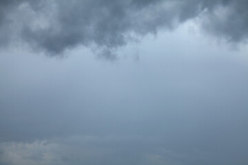 Atmosphere and formation of rain. Low hanging clouds with rain on the background of a gray sky....