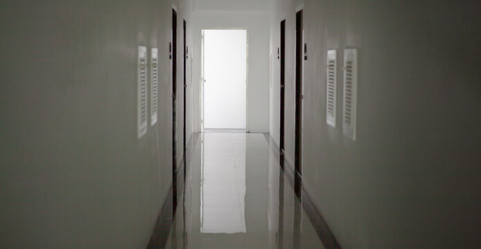 White Hotel Hallway With Many Doors And Lights