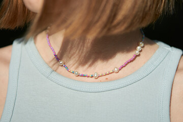 Modern jewelry made of beads and beads on the girl's neck. multi-colored jewelry made of beads and...