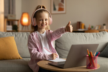 School Girl Showing Thumbs Up To Laptop Wearing Headset Indoor