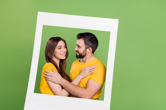 Portrait of attractive lady handsome guy cuddle look each other camera card isolated on green color background