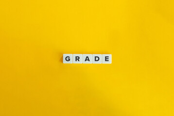 Grade Word on Letter Tiles on Yellow Background. Minimal Aesthetics.