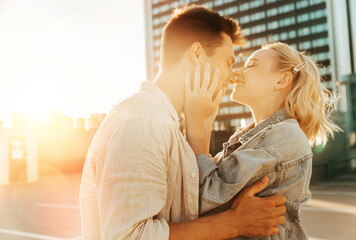 summer holidays, love and people concept - happy young couple hugging on roof top city parking