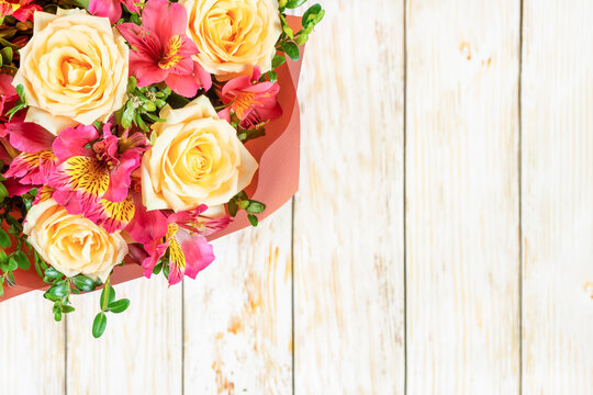 Bouquet of beautiful roses and alstroemeria on white wooden background. Fresh, lush bouquet of colorful flowers for wedding, valenitnes day, mother day. Floral shop concept, mockup with copy space