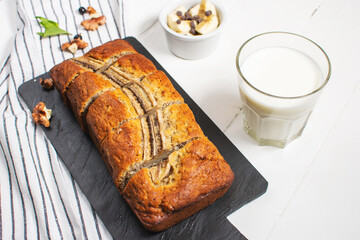 Banana bread or cake on white wooden table. Delicious homemade dessert, tasty snack or morning breakfast